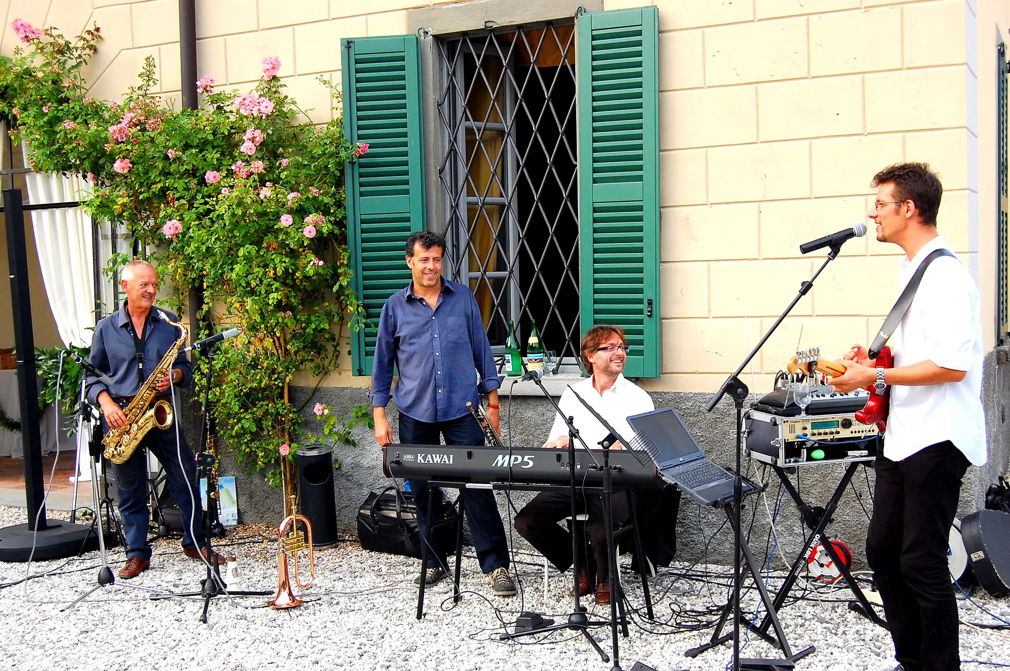 Un groupe de musiciens devant la maison, parmi les roses