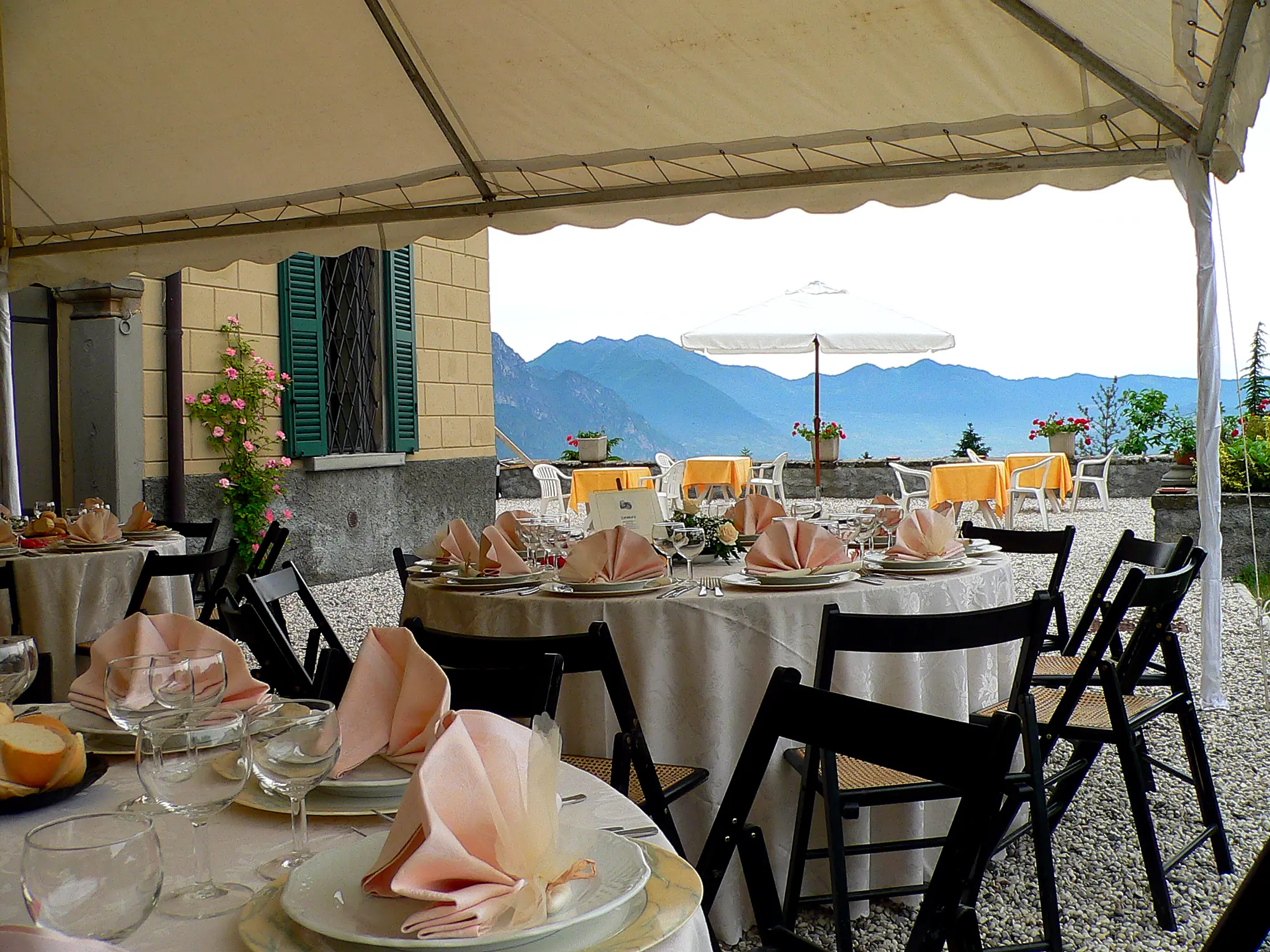 Des tables dressées sous un gazebo, avec le lac d'Iseo