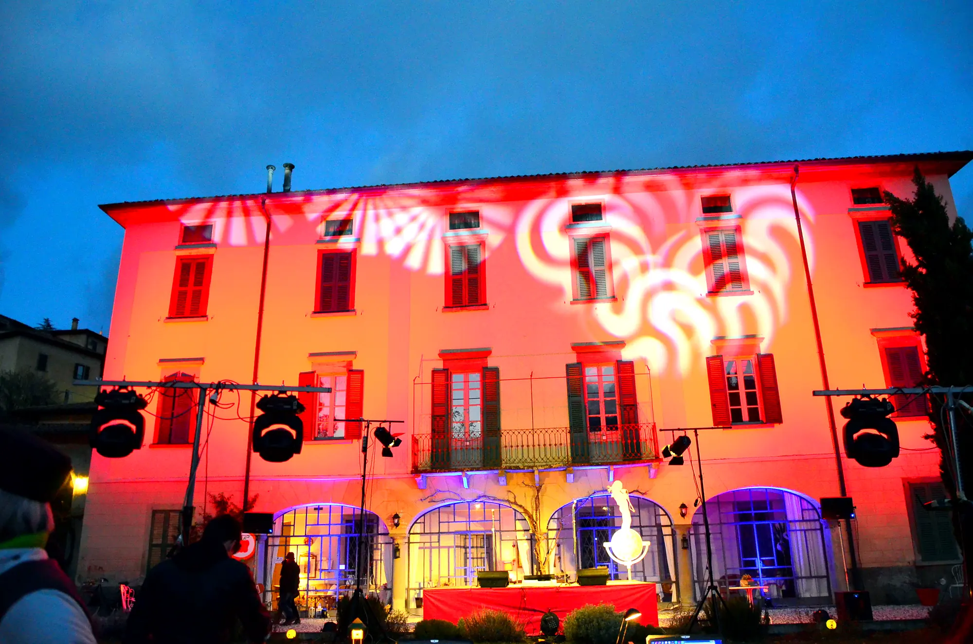 La façade de la demeure éclairée en rouge pendant un spectacle en soirée