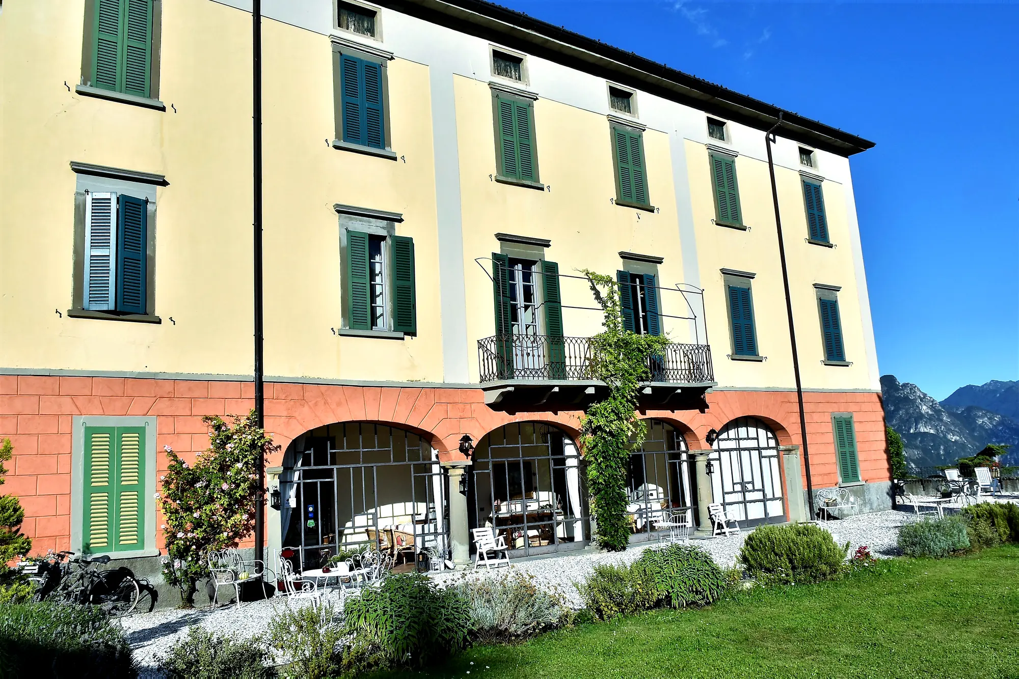 The façade with the arched terracotta-coloured veranda, the wisteria and the glazing